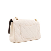 Cremefarbene Chanel Timeless Handtasche Double Flap Bag Medium Größe aus hellem Raffia Stroh Material mit goldener Hardware halb seitlich links 