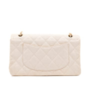 Cremefarbene Chanel Timeless Handtasche Double Flap Bag Medium Größe aus hellem Raffia Stroh Material mit goldener Hardware Rückansicht 