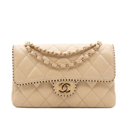 Beige Chanel Timeless Handtasche Single Flap Bag Medium Größe aus Lammleder Material mit goldener Hardware und schwarzer Trimm Zierborte Frontansicht 