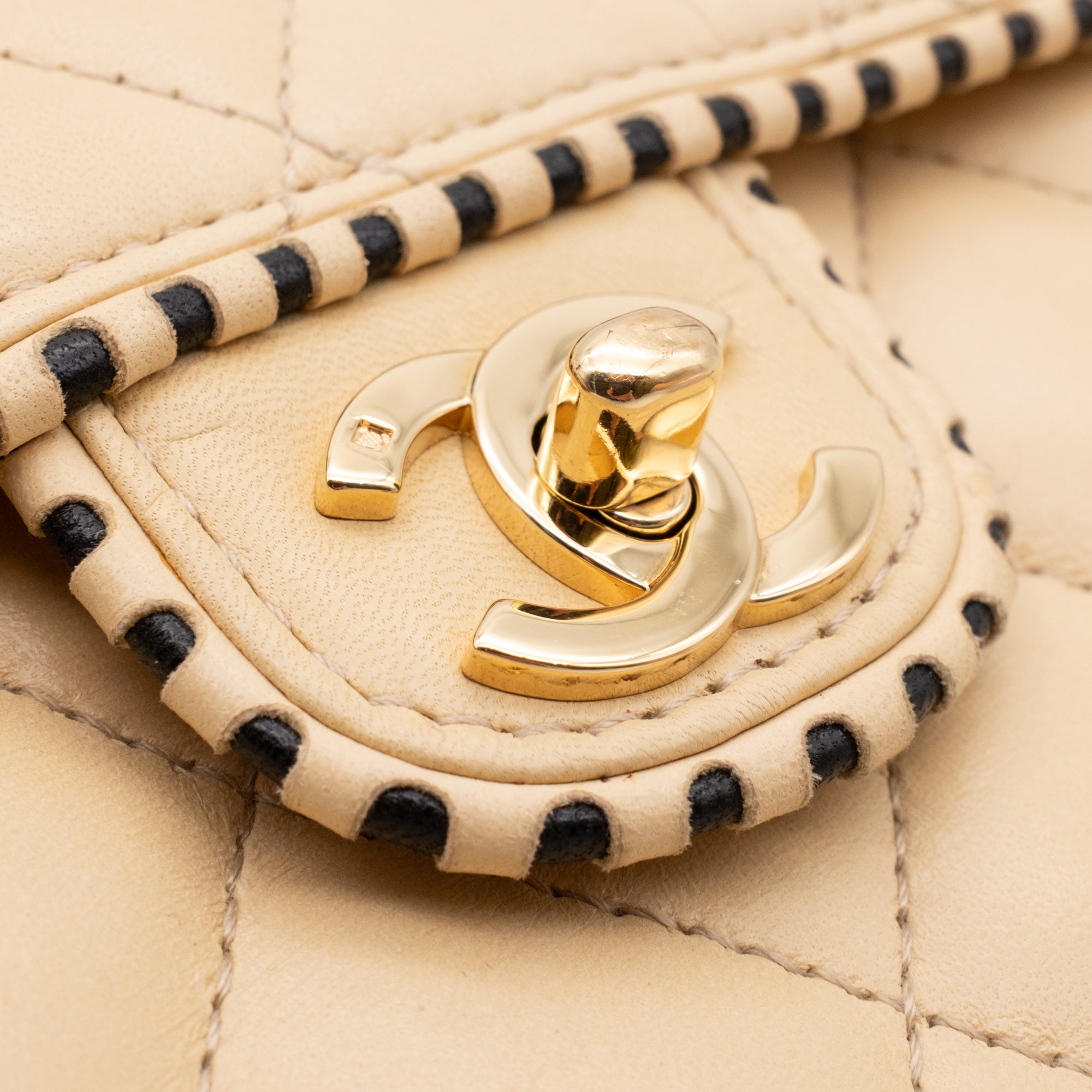 Beige Chanel Timeless Handtasche Single Flap Bag Medium Größe aus Lammleder Material mit goldener Hardware und schwarzer Trimm Zierborte Detail CC Lock