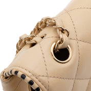 Beige Chanel Timeless Handtasche Single Flap Bag Medium Größe aus Lammleder Material mit goldener Hardware und schwarzer Trimm Zierborte Detail Ösen