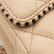 Beige Chanel Timeless Handtasche Single Flap Bag Medium Größe aus Lammleder Material mit goldener Hardware und schwarzer Trimm Zierborte Detail Zierborte 