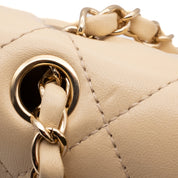 Beige Chanel Timeless Handtasche Single Flap Bag Medium Größe aus Lammleder Material mit goldener Hardware und schwarzer Trimm Zierborte Detail Öse