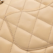 Beige Chanel Timeless Handtasche Single Flap Bag Medium Größe aus Lammleder Material mit goldener Hardware und schwarzer Trimm Zierborte Detail Rückseite
