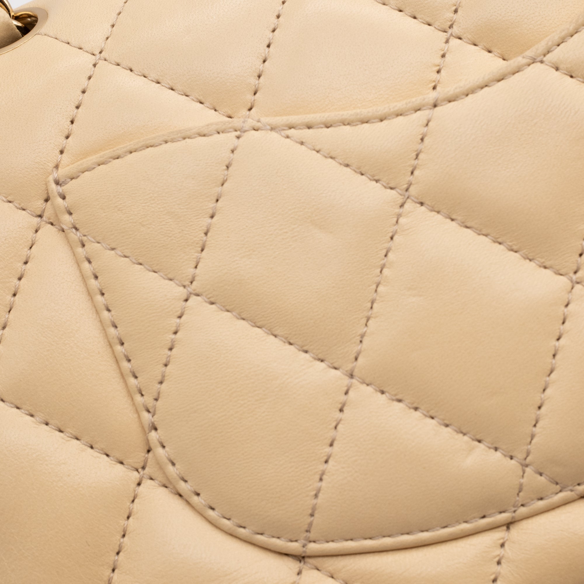 Beige Chanel Timeless Handtasche Single Flap Bag Medium Größe aus Lammleder Material mit goldener Hardware und schwarzer Trimm Zierborte Detail Rückseite
