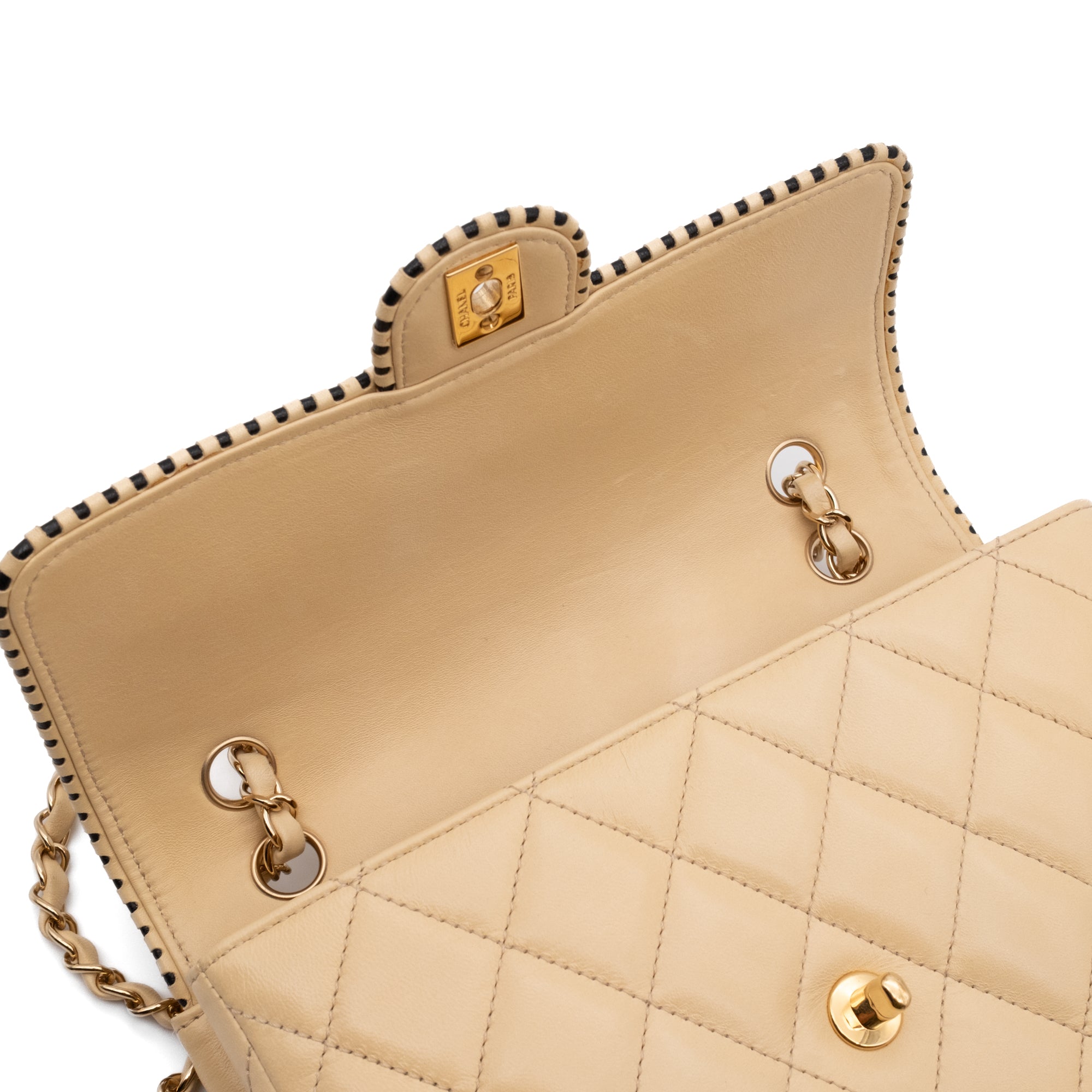 Beige Chanel Timeless Handtasche Single Flap Bag Medium Größe aus Lammleder Material mit goldener Hardware und schwarzer Trimm Zierborte Innere Klappe