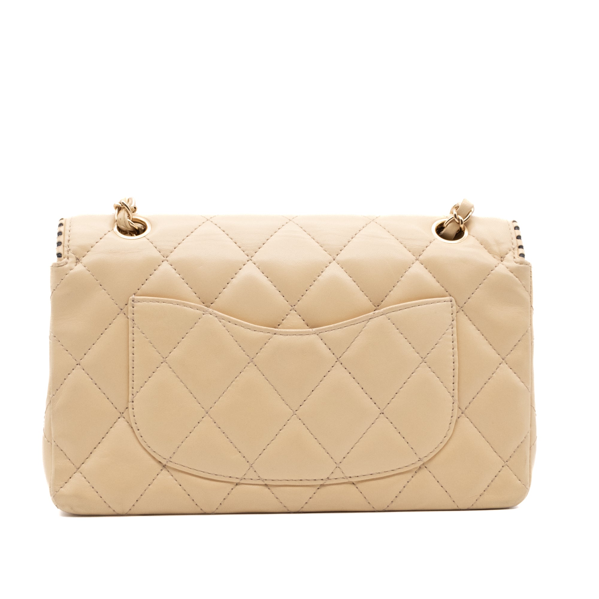 Beige Chanel Timeless Handtasche Single Flap Bag Medium Größe aus Lammleder Material mit goldener Hardware und schwarzer Trimm Zierborte Rückseite 