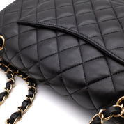Schwarze Chanel Timeless Handtasche Double Flap Bag Medium Größe aus Lammleder mit goldener Hardware Detail Lederfalten außen hinten