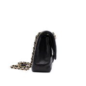 Schwarze Chanel Timeless Handtasche Double Flap Bag Medium Größe aus Lammleder mit goldener Hardware Seitenansicht links