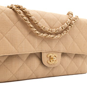 Beige Chanel Timeless Handtasche Double Flap Bag Medium Größe aus beigem Raffia Stroh Material mit goldener Hardware Detail seitlich Logo